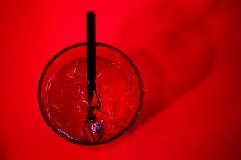 Top View of Red Cocktail with Ice and Black Straw