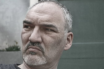 Close-up portrait of mature man with gray beard looking away