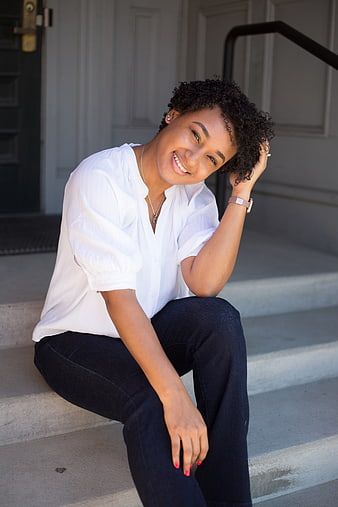 Smiling young woman sitting on outdoor steps