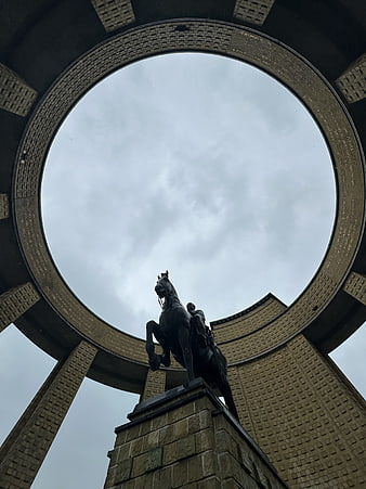Low angle view of equestrian statue framed by circular brick architecture