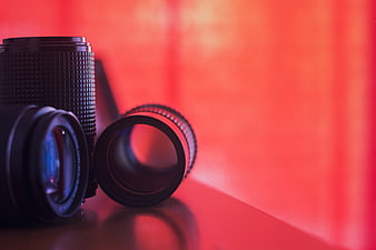 Black Camera Lenses on Red Background with Reflection