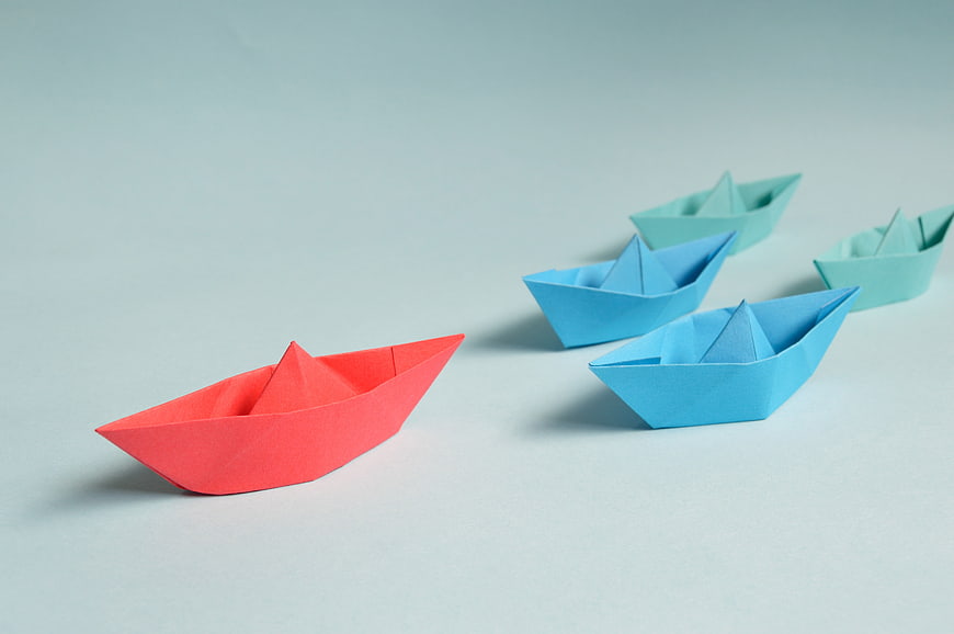 Red Origami Boat Leading Blue Paper Boats Concept
