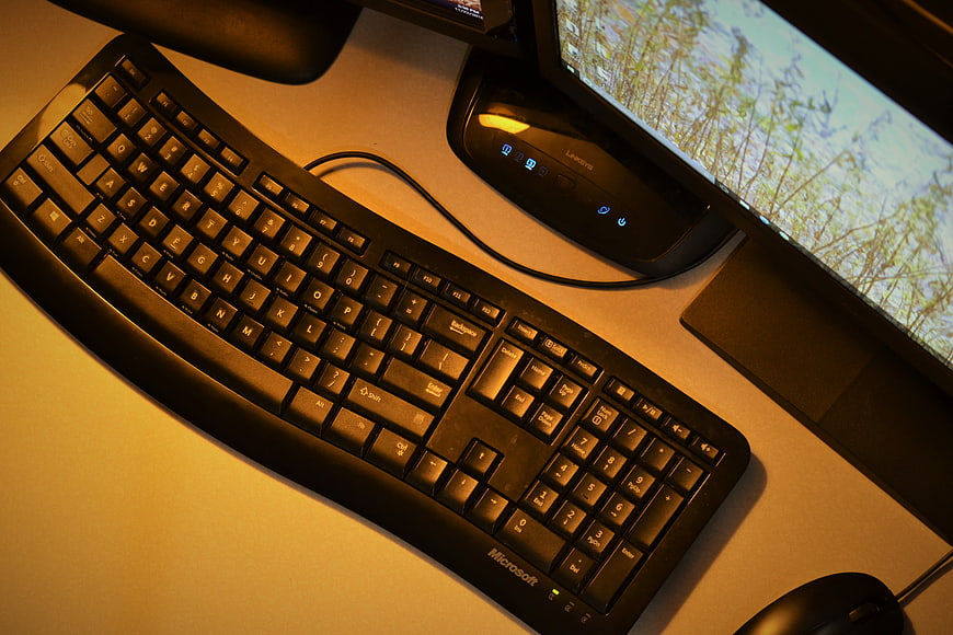 Black Microsoft Keyboard and Monitor on Desk