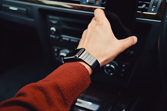 Man holding smartphone in car with smartwatch