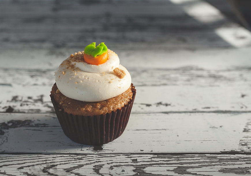 Carrot Cupcake With Cream Topping On Rustic White Wooden Table