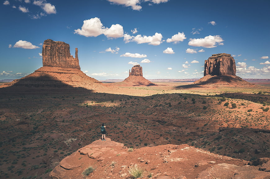 Hiker overlooking Monument Valley desert landscape