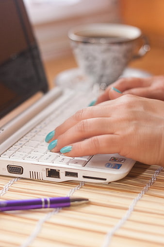 Close-up of Woman Typing on White Laptop with Coffee