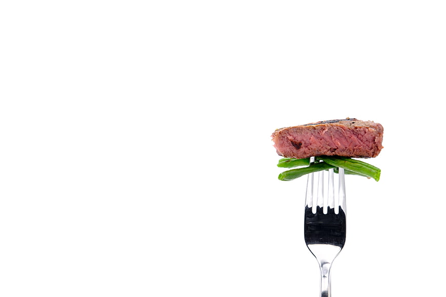 Rare Steak And Green Beans On Fork Against White Background