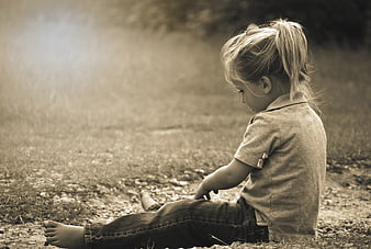 Toddler girl sitting on dirt path in sepia tone