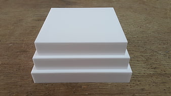 Stacked White Acrylic Blocks on Wooden Surface