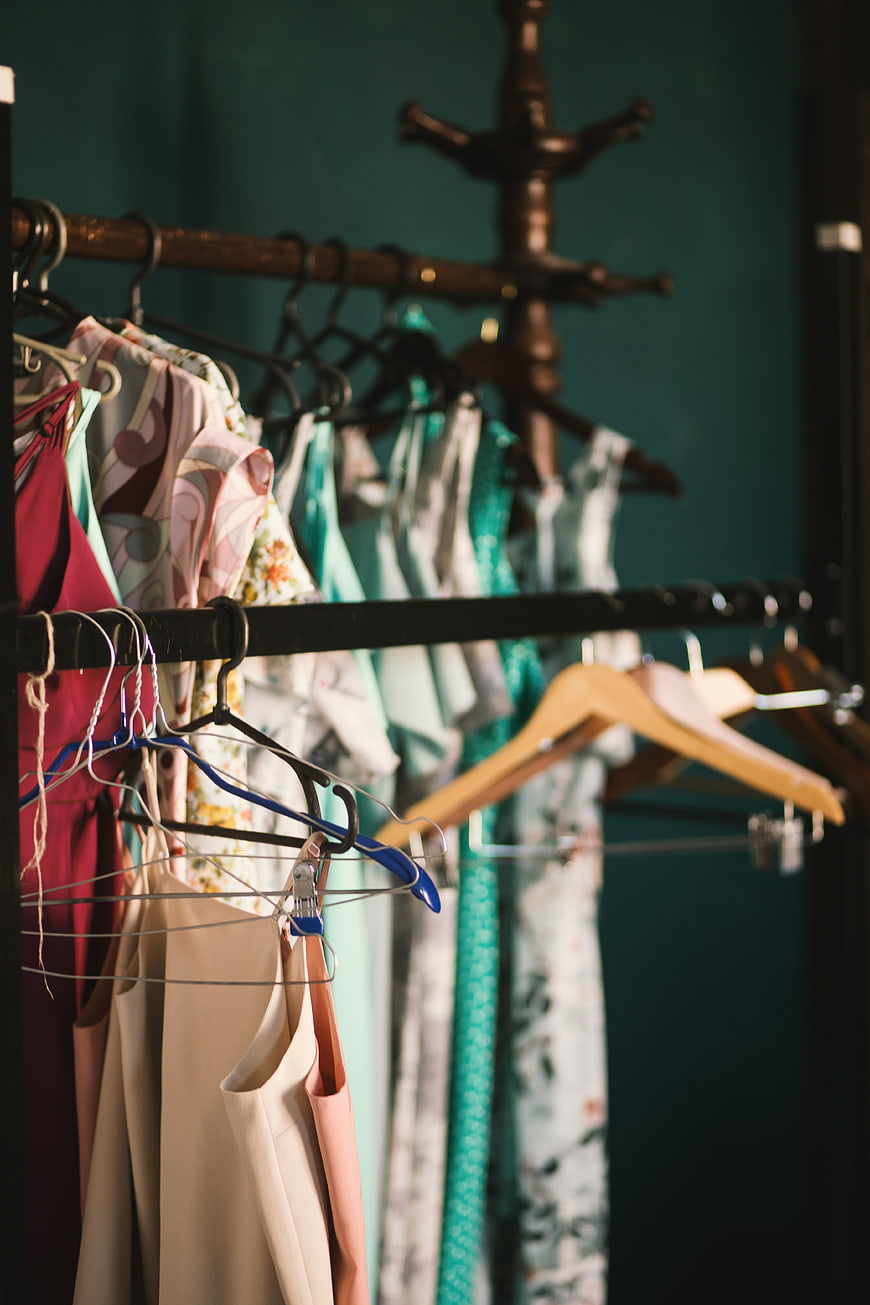 Clothing rack with colorful dresses and hangers in boutique