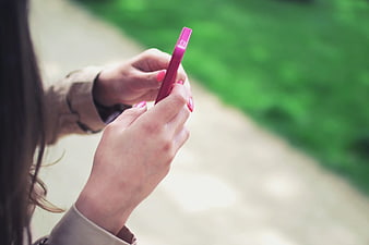 Close-up of Woman Holding Pink Smartphone Outdoors