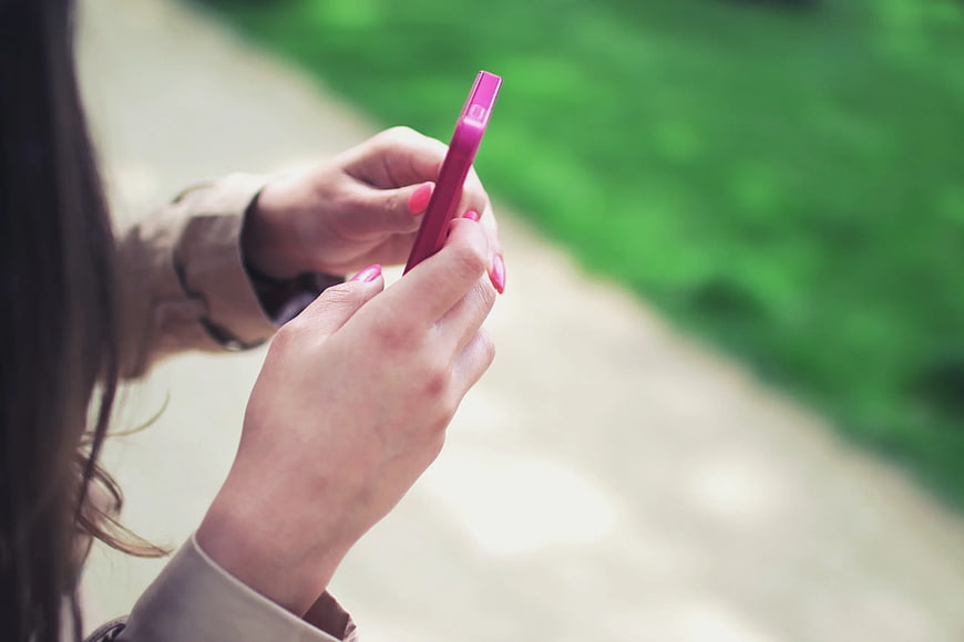 Close-up of Woman Holding Pink Smartphone Outdoors