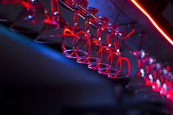 Wine Glasses Hanging in Neon Lit Bar