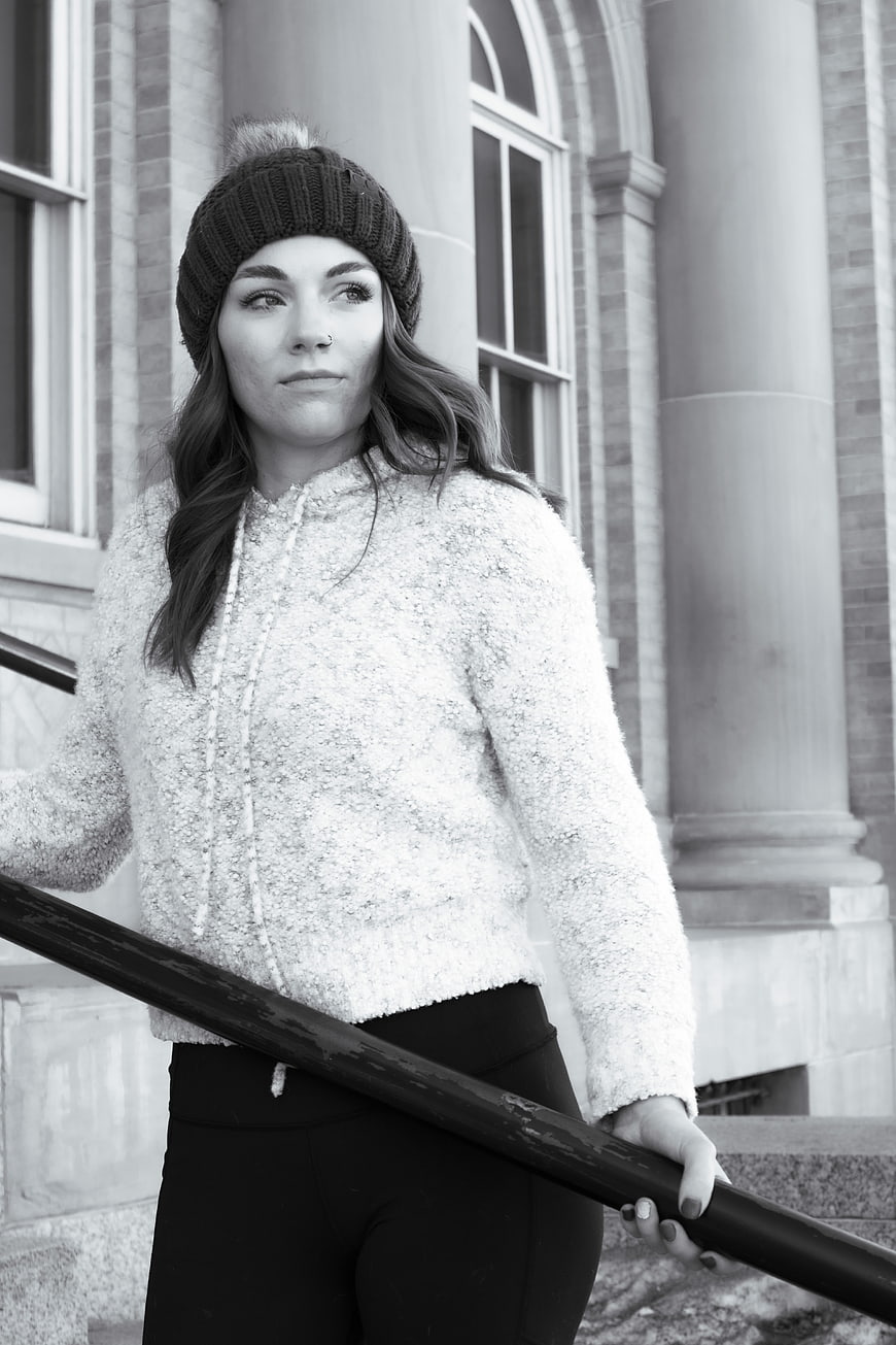 Young Woman in Beanie and Fleece Jacket on Outdoor Stairs