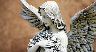 Close-up of a white stone angel statue holding roses