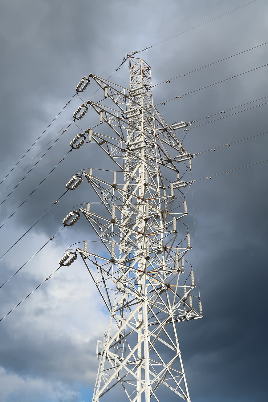High Voltage Power Line Tower Against Stormy Sky