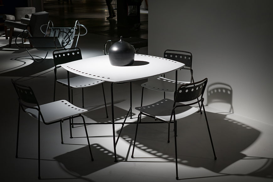 Modern minimalist dining table and chairs with dramatic shadows