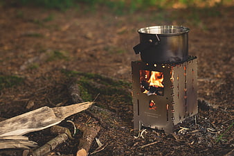 Portable titanium wood stove with pot in forest