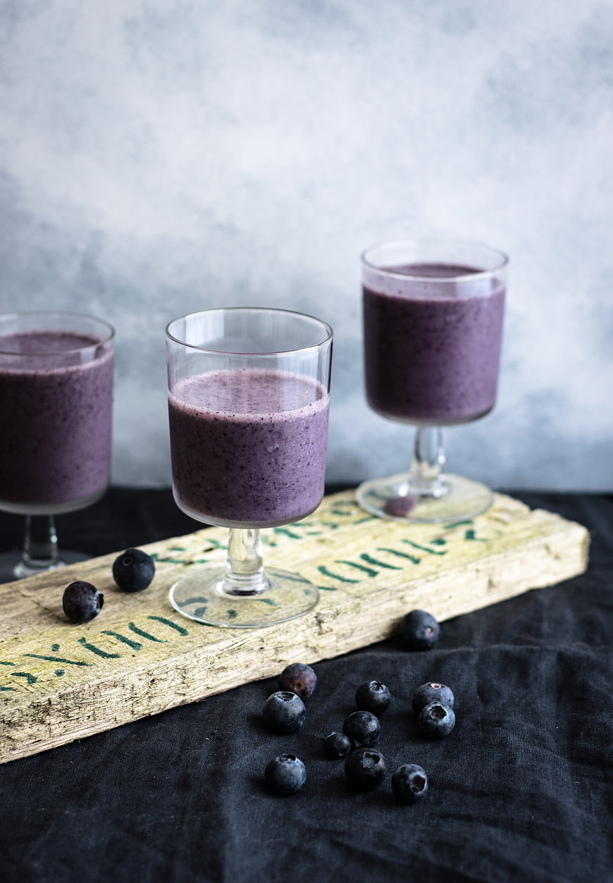 Fresh Blueberry Smoothie in Glasses on Rustic Wood