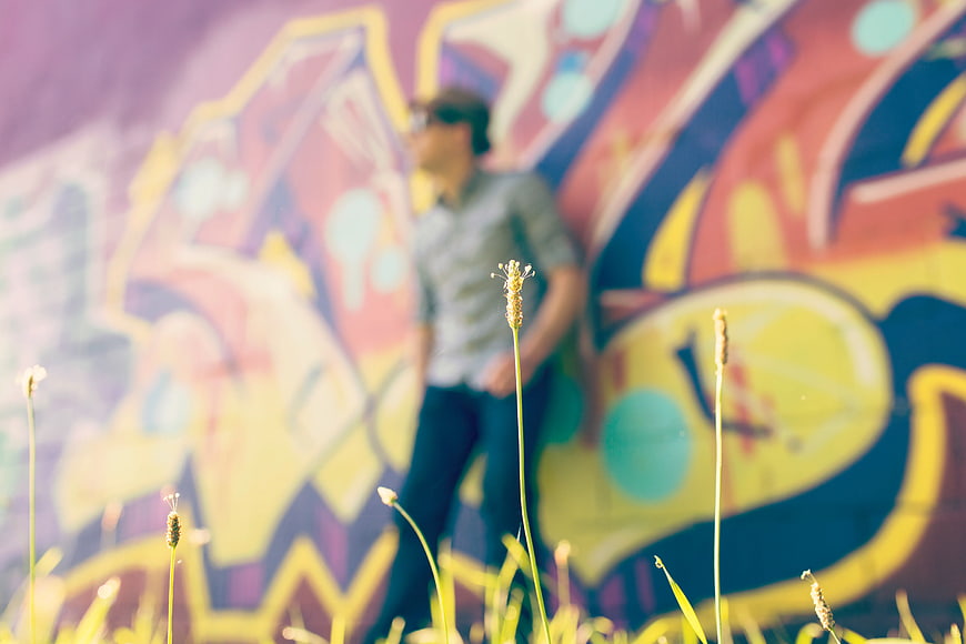 Blurred Man Leaning Against Colorful Graffiti Wall