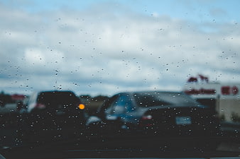 Raindrops on car windshield with blurred traffic background