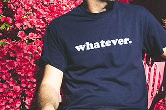 Man Wearing Navy T-Shirt with White Text Against Pink Flowers