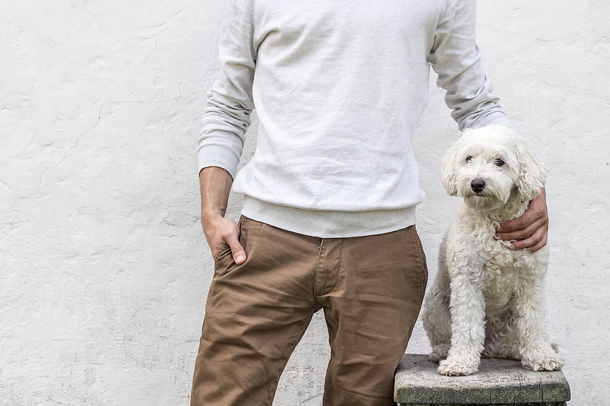 Man with White Dog Against White Wall