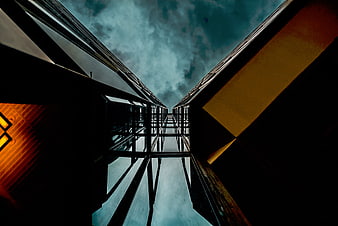 Low angle view of modern glass skyscrapers against cloudy sky