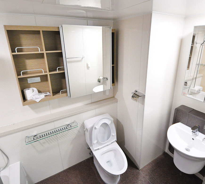 Compact Modern Bathroom Interior With White Toilet And Wall Sink
