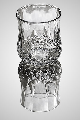 Crystal Cut Glass Tumbler with Reflection on Gray Background