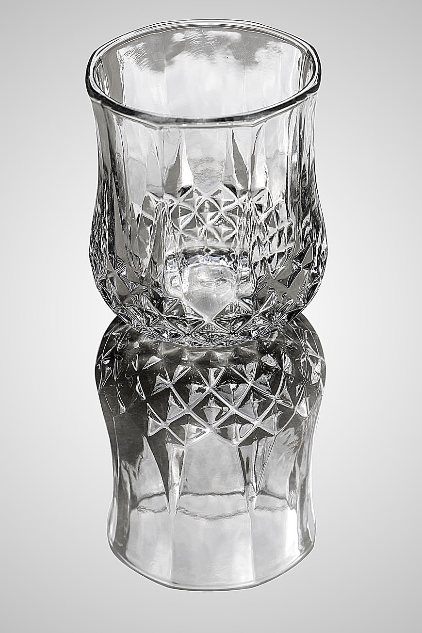 Crystal Cut Glass Tumbler with Reflection on Gray Background