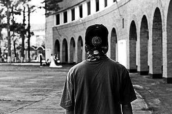 Back view of person in cap looking at wedding couple