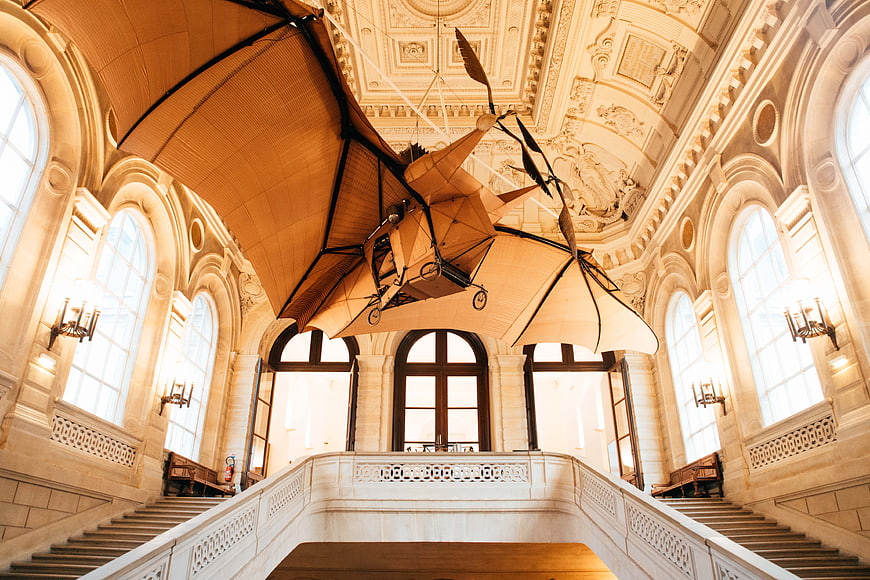 Vintage ornithopter model hanging in grand museum hall