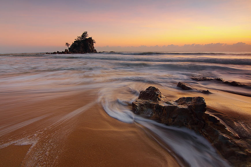 Long Exposure Sunset Seascape with Silhouetted Rock Formation