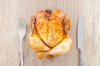 Roasted Whole Chicken on Wooden Table with Cutlery