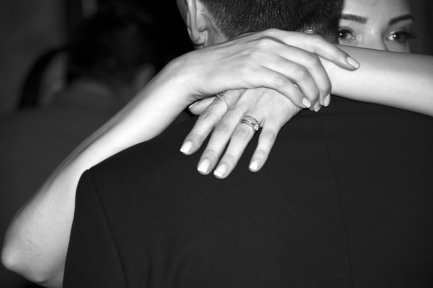 Close-up of couple hugging with wedding ring visible