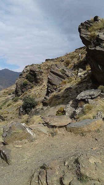 Rugged mountain landscape with rocky terrain and dry grass