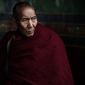 Portrait of elderly Tibetan monk in maroon robes