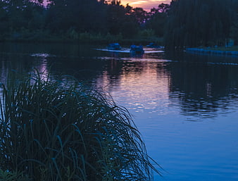 Peaceful Lake Sunset with Boats and Reeds