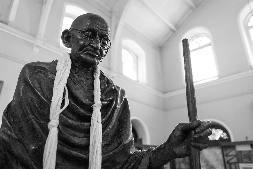 Black and white statue of Mahatma Gandhi holding a staff