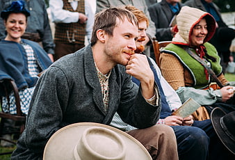 Man in Historical Costume Smiling at Outdoor Gathering