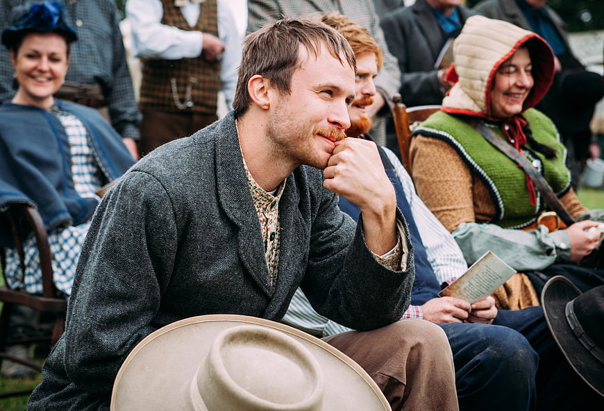 Man in Historical Costume Smiling at Outdoor Gathering