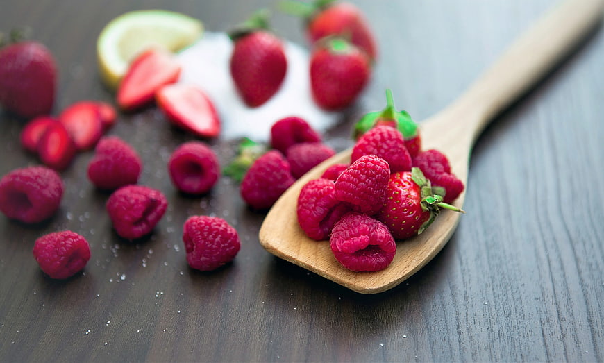 Fresh Raspberries and Strawberries on Wooden Spoon