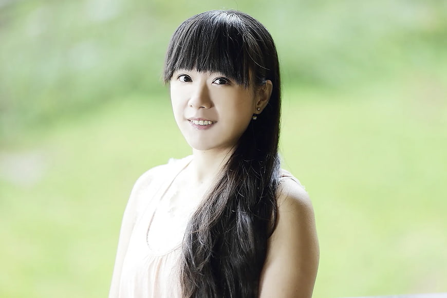 Portrait of smiling Asian woman with long black hair outdoors