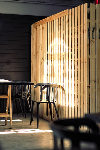 Sunlight casting shadows on wooden slat partition in modern interior