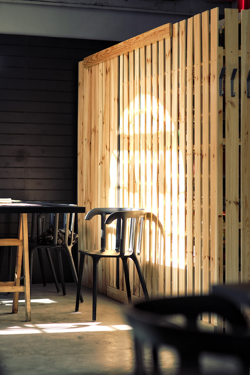 Sunlight casting shadows on wooden slat partition in modern interior