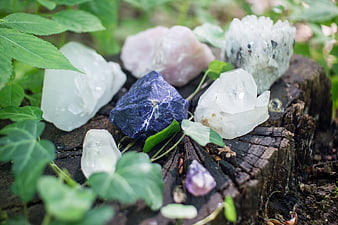 Raw crystals and gemstones on a wooden stump in nature
