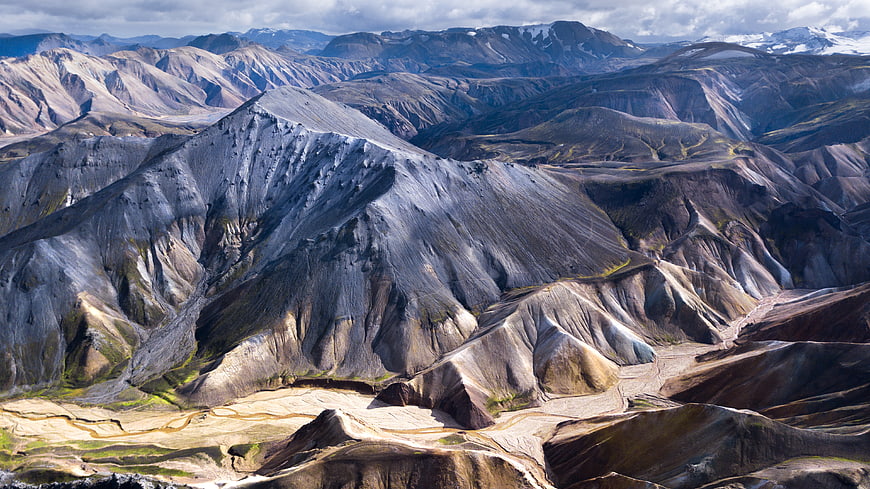 Dramatic volcanic landscape with rugged mountains and snow-capped peaks