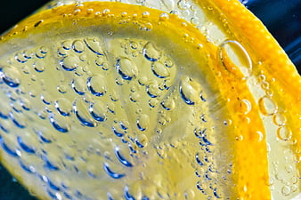 Macro close-up of a lemon slice with water droplets and bubbles